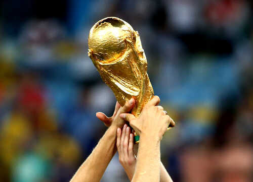 Hands holding the FIFA World Cup trophy aloft in celebration