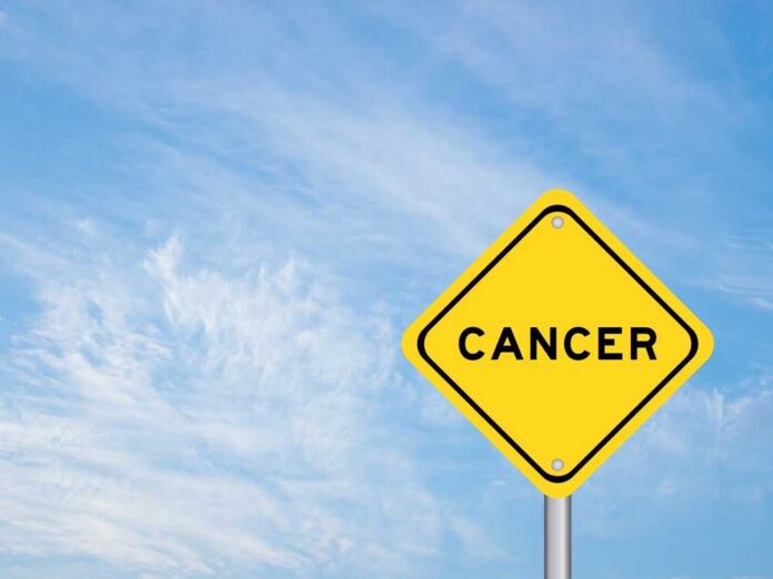 shutterstock_2067082901.jpg Yellow warning sign displaying the word 'CANCER' against a blue sky