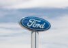 Ford logo displayed on a sign against a cloudy sky