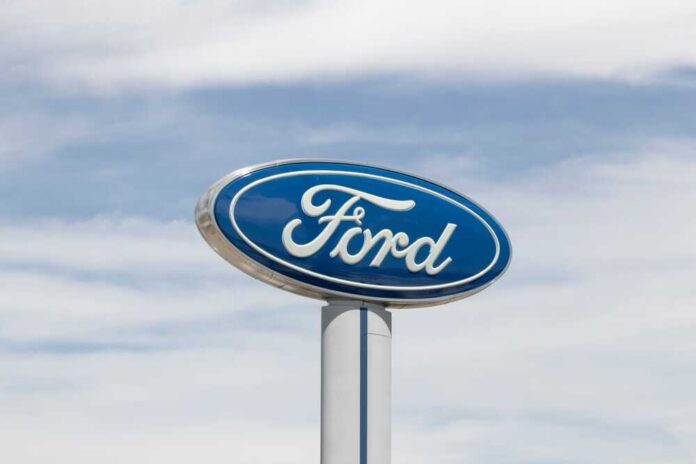 Ford logo displayed on a sign against a cloudy sky