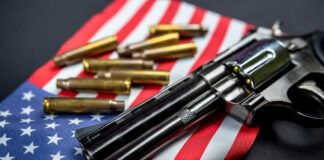 Revolver and bullets on American flag background.
