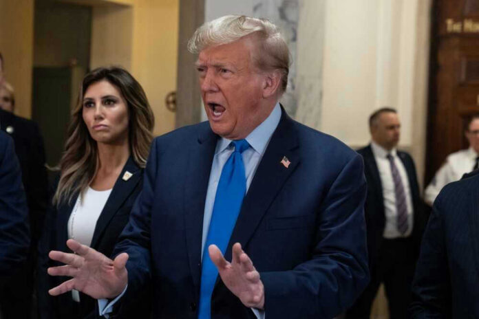 Donald Trump in a suit speaking to a crowd.