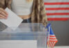 Person casting vote into a ballot box.