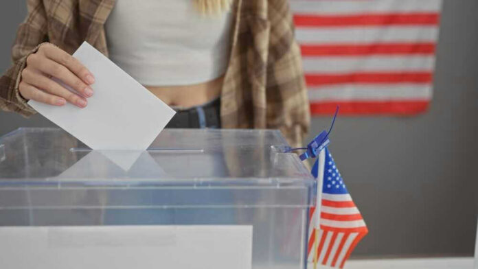 shutterstock_2445679271 Person casting vote into a ballot box.