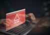 Warning message about a scam displayed on a laptop screen