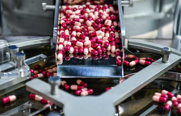 Medicine,Capsule,Pill,In,Production,Line,At,Medical,Factory,,Industrial Capsules being processed on a conveyor in a pharmaceutical facility