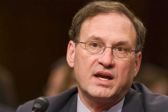 Samuel Alito speaking into a microphone.