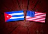 Cuban and American flags placed on a wooden surface