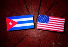 Cuban and American flags placed on a wooden surface