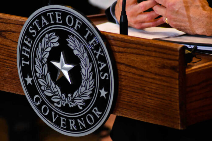 shutterstock_1128379292 Seal of Texas Governor on wooden podium.
