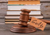 Guilty — But How Many More Did He Kill? (VIDEO) A wooden gavel with a tag reading 'Guilty' next to stacked books