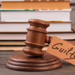 Guilty — But How Many More Did He Kill? (VIDEO) A wooden gavel with a tag reading 'Guilty' next to stacked books