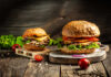 Burger Tax Panic Masks The Real Bite Gourmet burgers on rustic wooden boards with fresh toppings