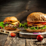 Gourmet burgers on rustic wooden boards with fresh toppings