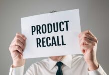 Person holding a sign reading product recall