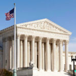 Supreme Court GUTS Gun Rule U.S. Supreme Court building with American flag.