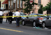Police and crime scene tape on city street.