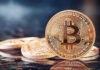 Bitcoin coins on a reflective surface.