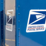 Stamp Shock: USPS Warns Cash Crisis Row of blue United States Postal Service mailboxes