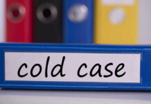 Blue binder labeled 'cold case' with other colored binders in the background