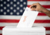Shock Poll: Democrats Surge Eight? Hand inserting mail-in ballot envelope into ballot box