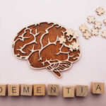 Blood Test Predicts Dementia Decades Early Wooden brain illustration with puzzle pieces and the word DEMENTIA spelled out in blocks