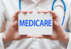 A medical professional holding a sign that says MEDICARE