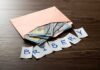 Congress Cash Games Crippled — Or Not? Envelope with cash and notes spelling bribery on wooden table