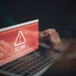 Warning message about a scam displayed on a laptop screen