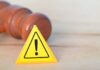 Supreme Court Shocker Reshapes Women’s Sports Yellow warning triangle with exclamation mark beside a wooden gavel