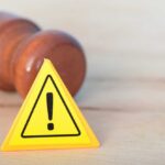Supreme Court Shocker Reshapes Women’s Sports Yellow warning triangle with exclamation mark beside a wooden gavel