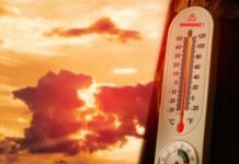 Heat Wave FORCES Wartime Power Play Thermometer displaying high temperature against a sunset background