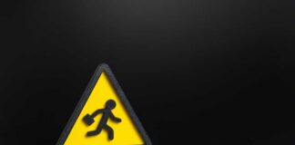 Yellow triangular warning sign with walking figure and briefcase on black background