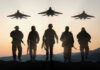 Pentagon Spin Meets Brutal Iran Reality Silhouettes of soldiers and jets at sunset.