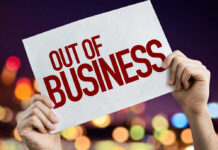 Hands holding an out of business sign