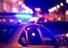 Massive Crackdown — Cartel Links Probed Police car with blue lights flashing at night.