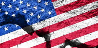 Cracked United States flag on textured surface.