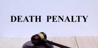 A wooden gavel resting on a block with the words 'DEATH PENALTY' in bold above it