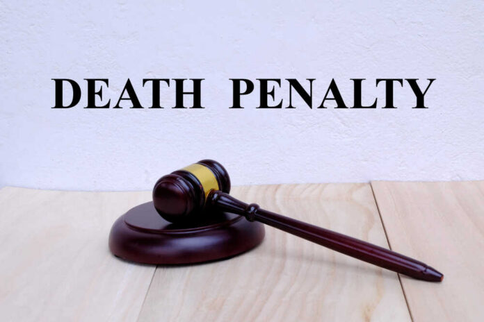 Death,Penalty,Written,On,The,Wall,With,Gavel,On,Wooden A wooden gavel resting on a block with the words 'DEATH PENALTY' in bold above it
