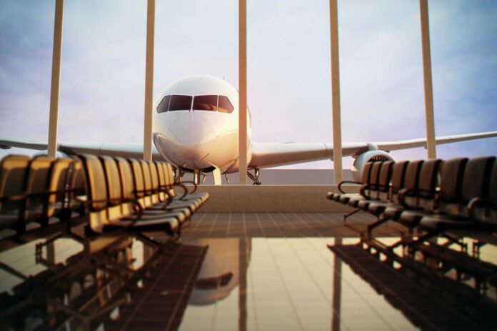shutterstock_124713472 Airplane viewed from an empty airport waiting area.