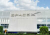 SpaceX building with logo and blue sky.