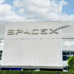 SpaceX building with logo and blue sky.