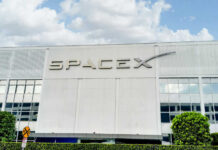 SpaceX building with logo and blue sky.
