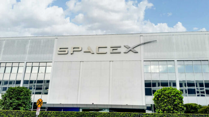 SpaceX building with logo and blue sky.