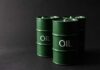 Green oil barrels on a dark background
