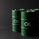 Green oil barrels on a dark background
