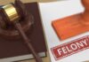 Judge's gavel on book beside paper stamped felony