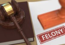Judge's gavel on book beside paper stamped felony