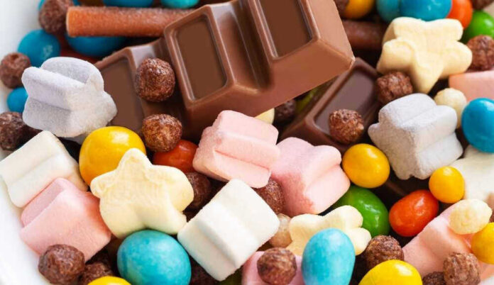 Colorful candies and chocolate bar close-up.