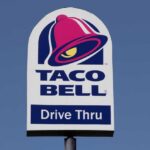 Taco Bell drive-thru sign against a clear blue sky